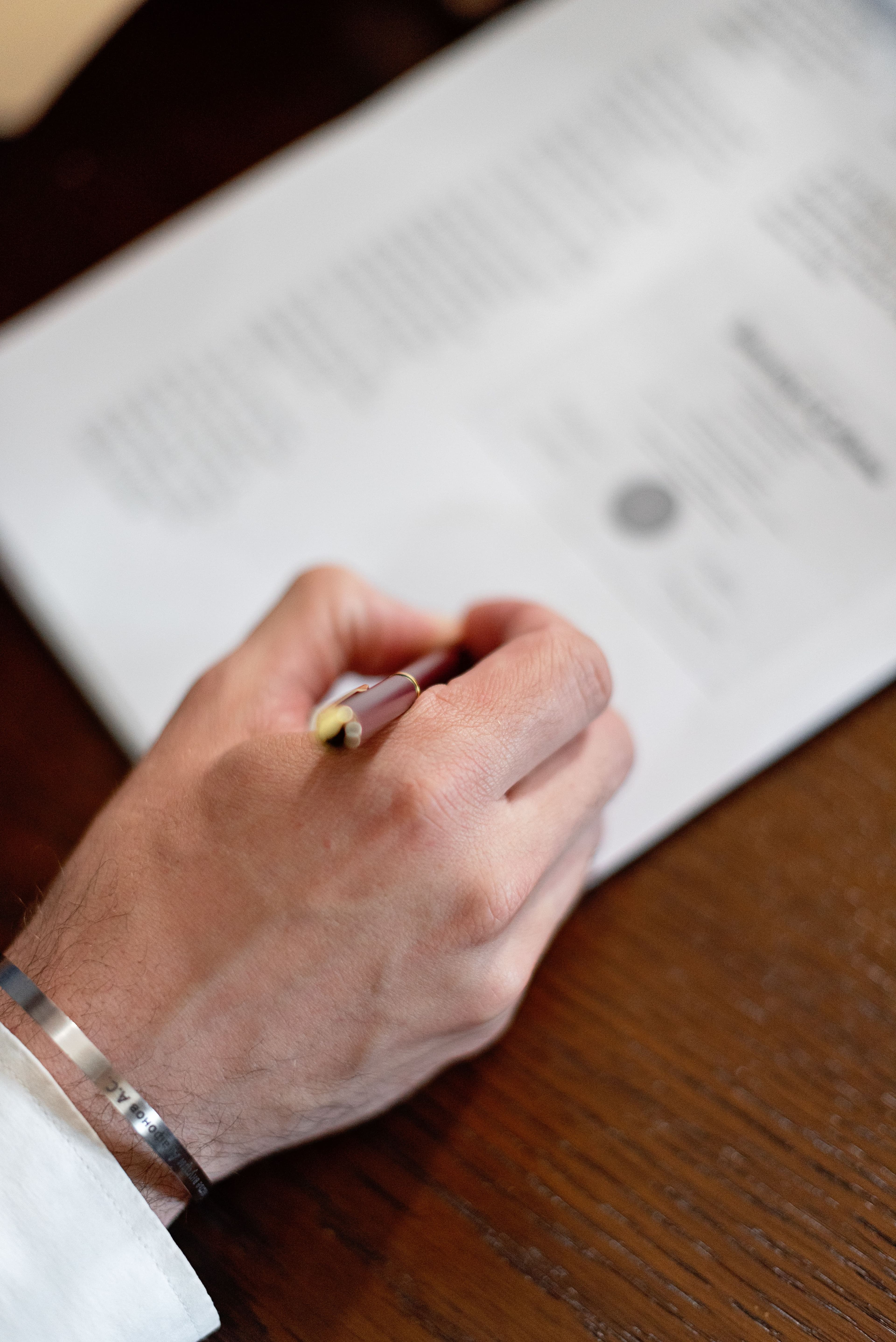 A hand reviewing and annotating a printed document with a pen